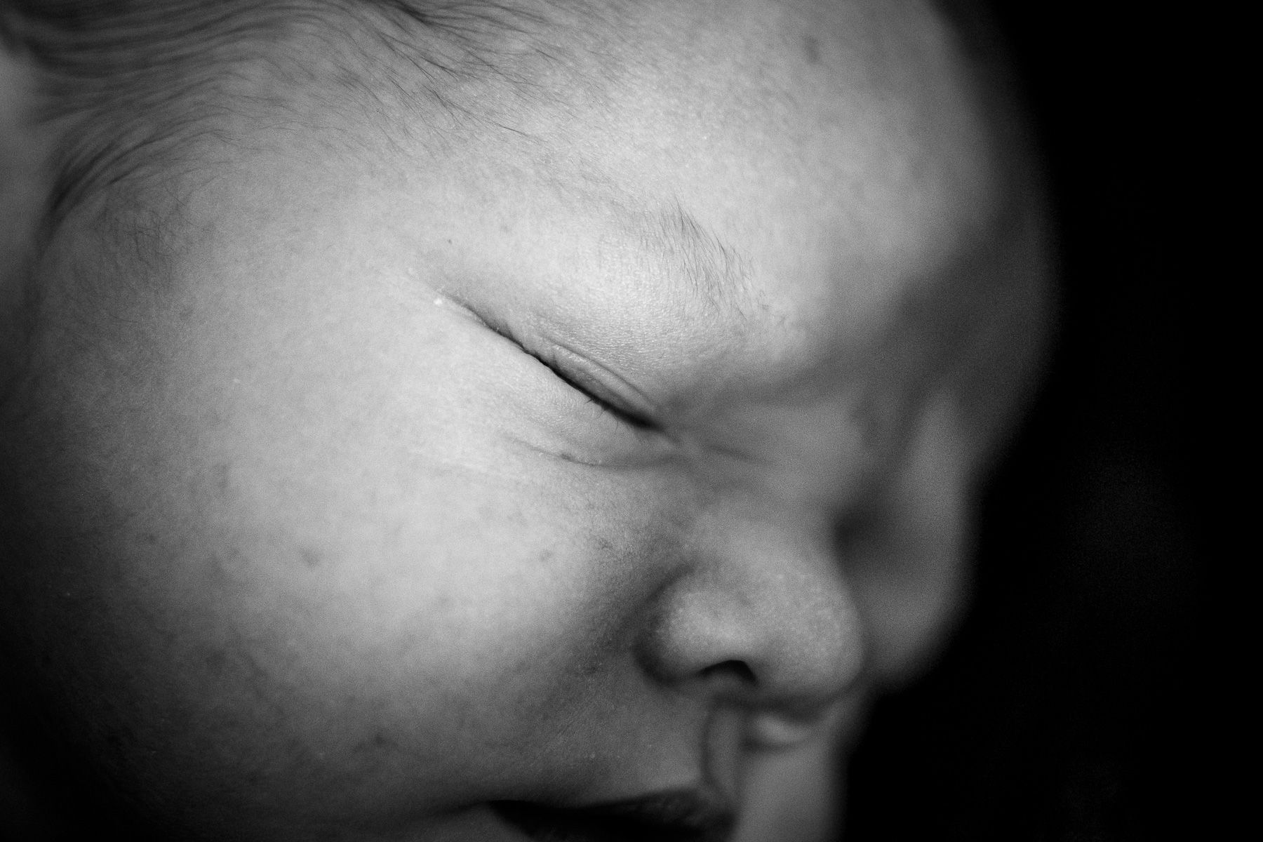 Close-up van het gezicht van een slapende pasgeboren baby.