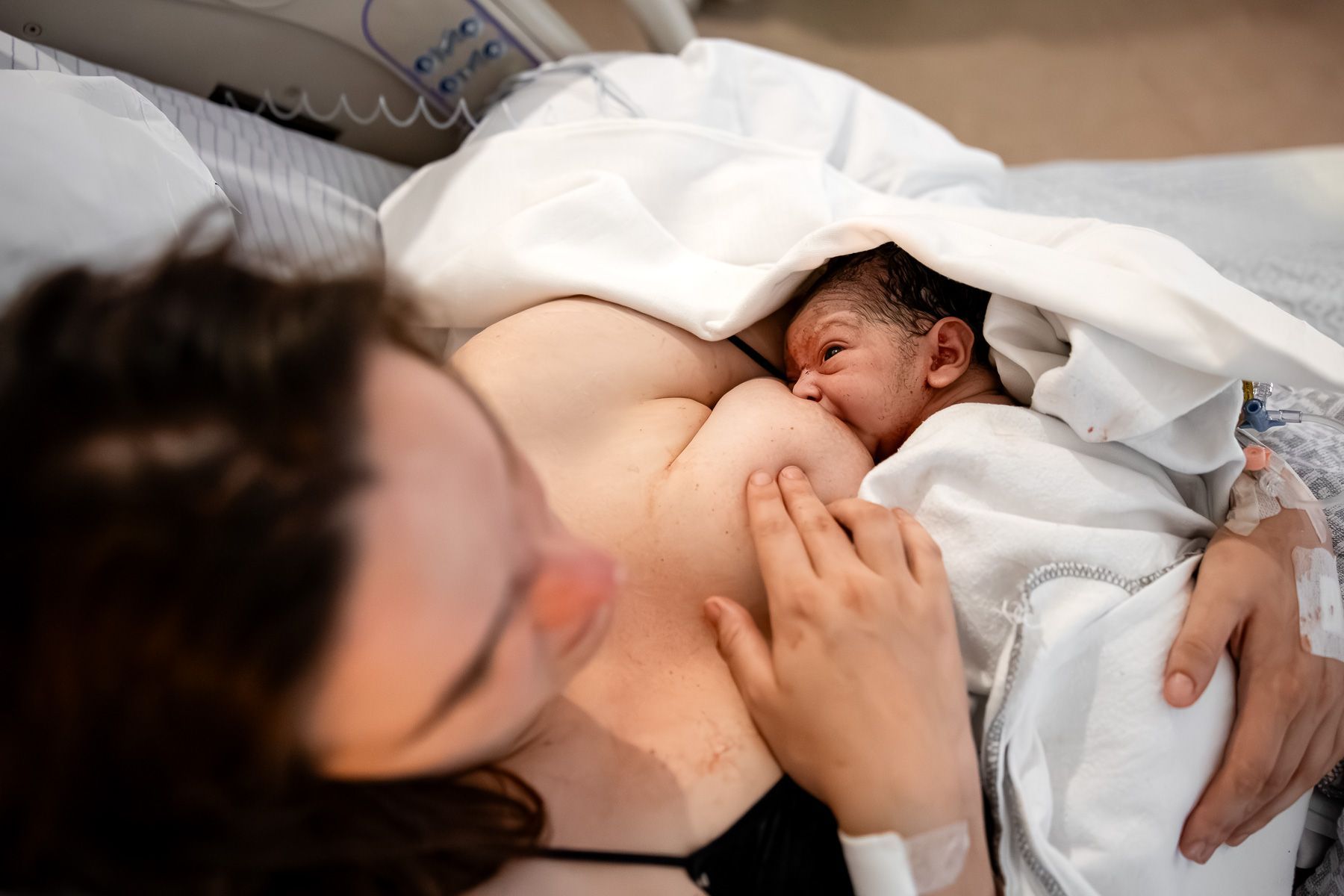 Pasgeboren baby drinkt voor het eerst aan de borst bij moeder na de geboorte