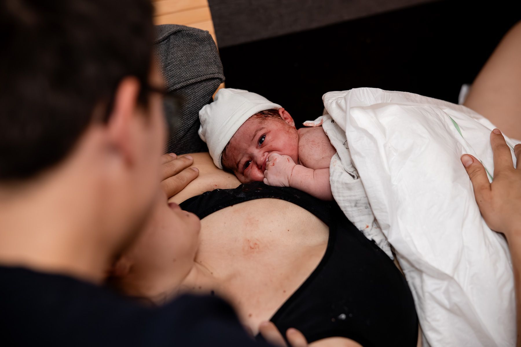 Ouders kijken naar hun pasgeboren baby vlak na de geboorte