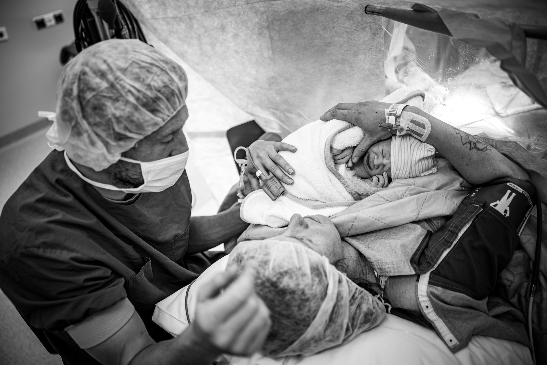 Pasgeboren baby wordt na een keizersnede in het ziekenhuis bij de ouders gelegd tijdens de eerste ontmoeting.