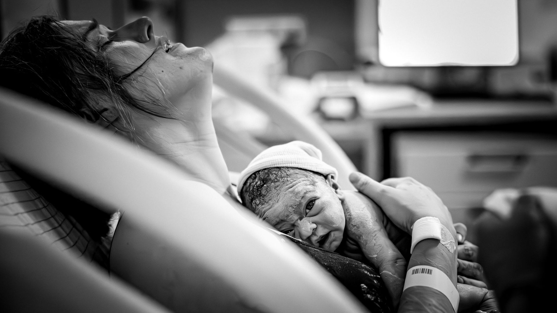Pasgeboren baby ligt direct na de geboorte op de borst van de moeder in het ziekenhuis.