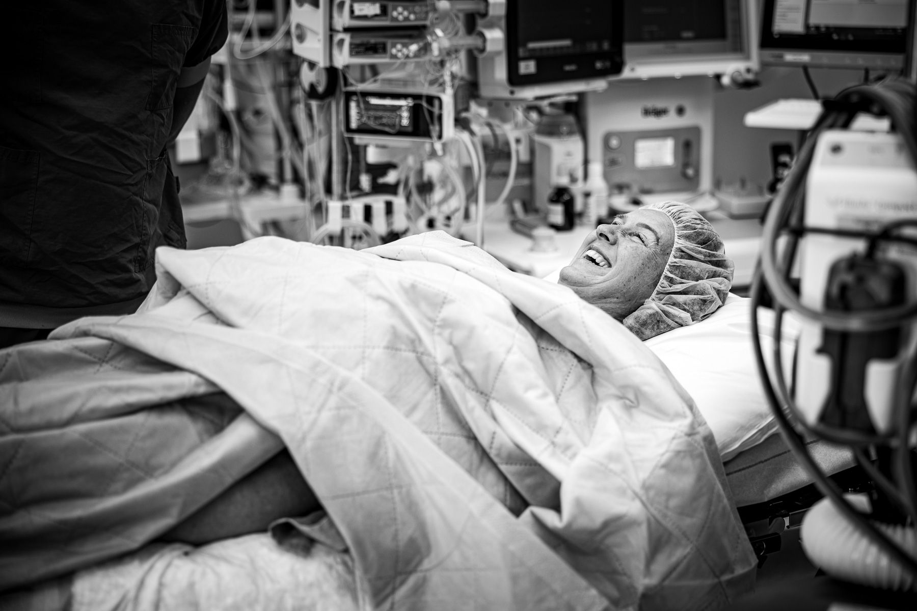 Moeder op de operatietafel tijdens een geplande keizersnede, ontspannen en lachend in de operatiekamer