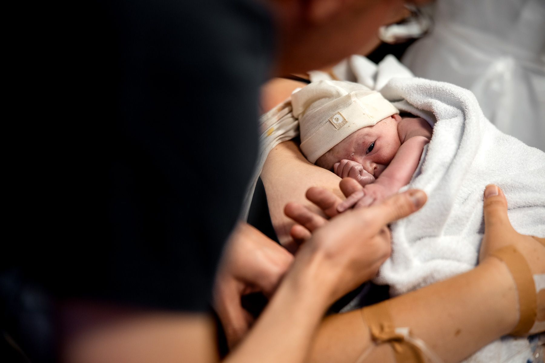 Ouders kijken naar hun pasgeboren baby in de eerste momenten na de geboorte.