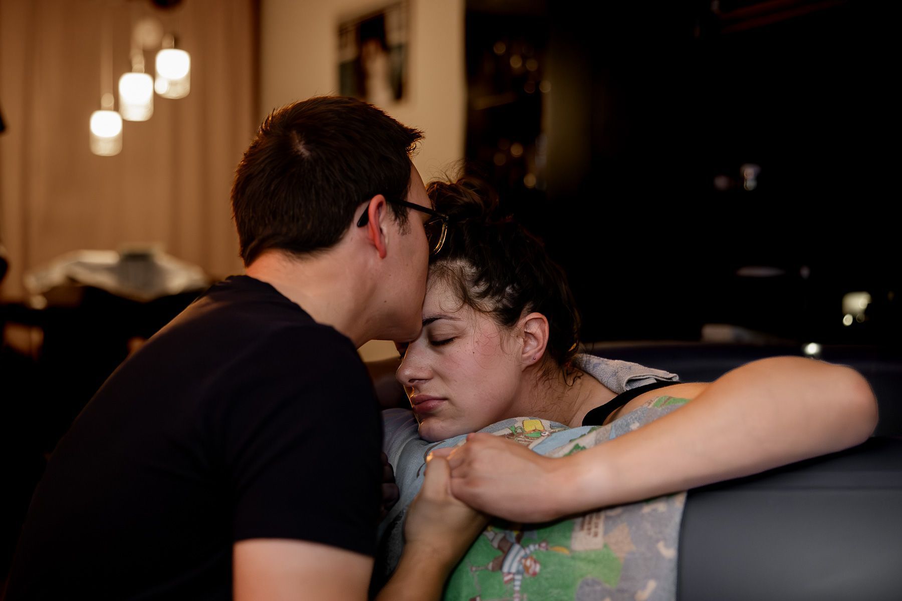 Partner kust vrouw op het voorhoofd tijdens de bevalling