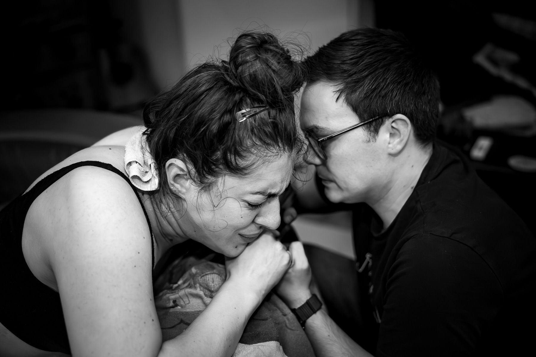 Partner ondersteunt vrouw terwijl zij een wee opvangt tijdens de bevalling