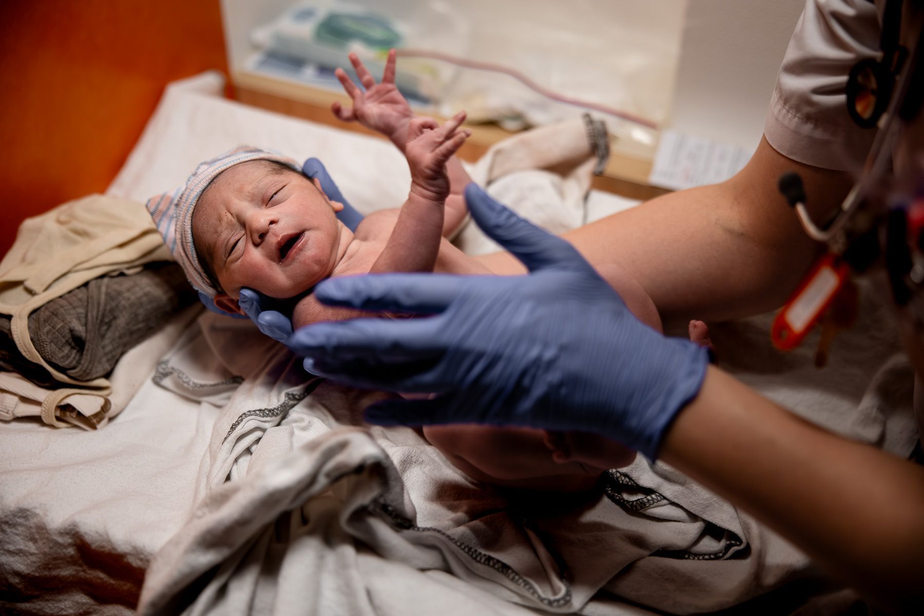 Pasgeboren baby wordt gecontroleerd door obstetrieverpleegkundige na de geboorte