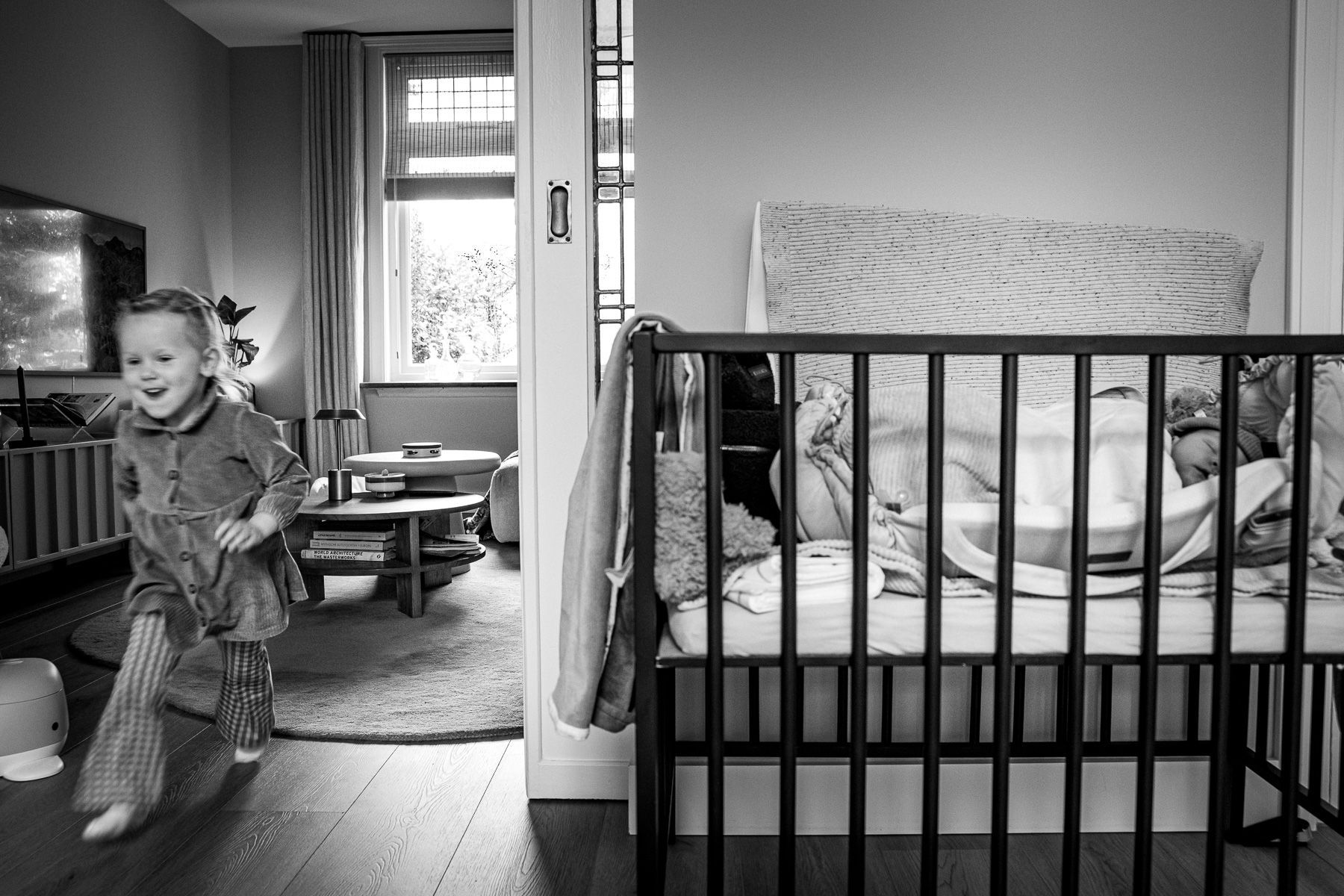 Peuter rent door huis tijdens kraamtijd baby in box