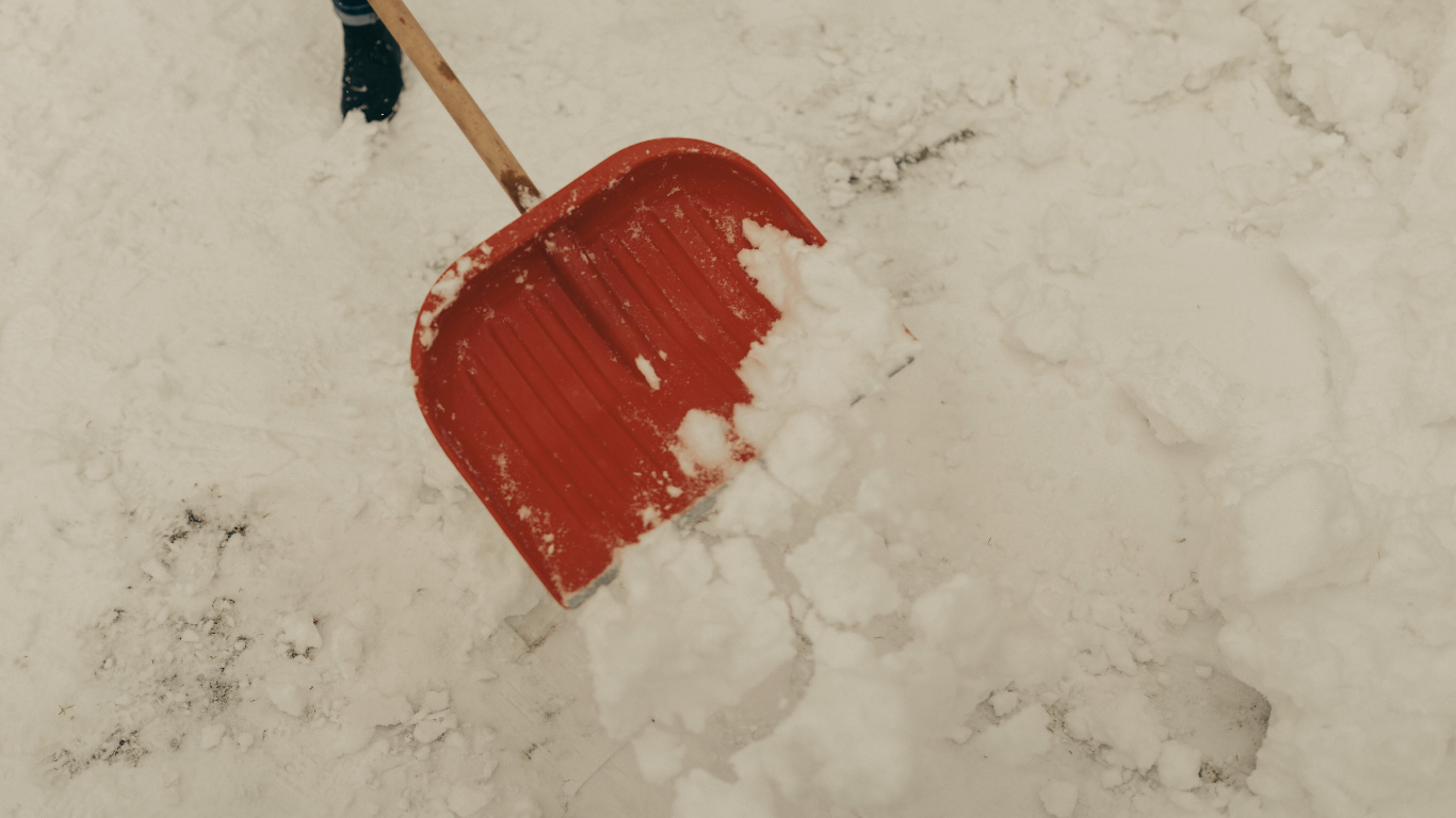 Red shovel scooping snow.