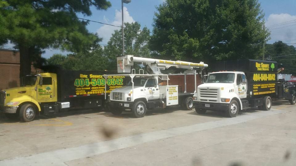 Three trucks are parked next to each other on the side of the road.