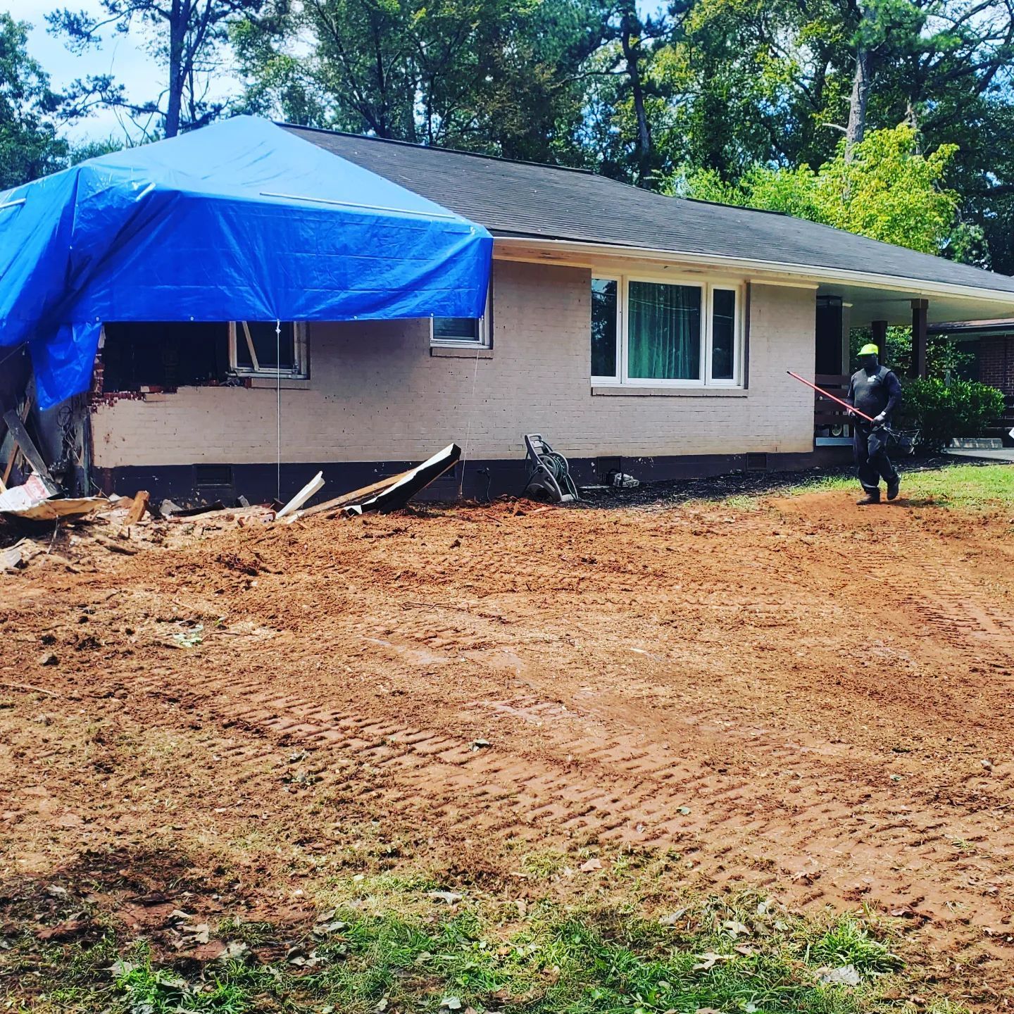 A house with a blue tarp on top of it
