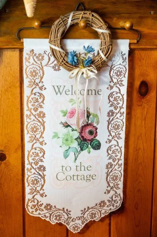 Wreath hanging above a welcome banner with floral design,