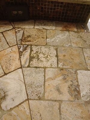 Stone wall with varying shades of tan and beige.