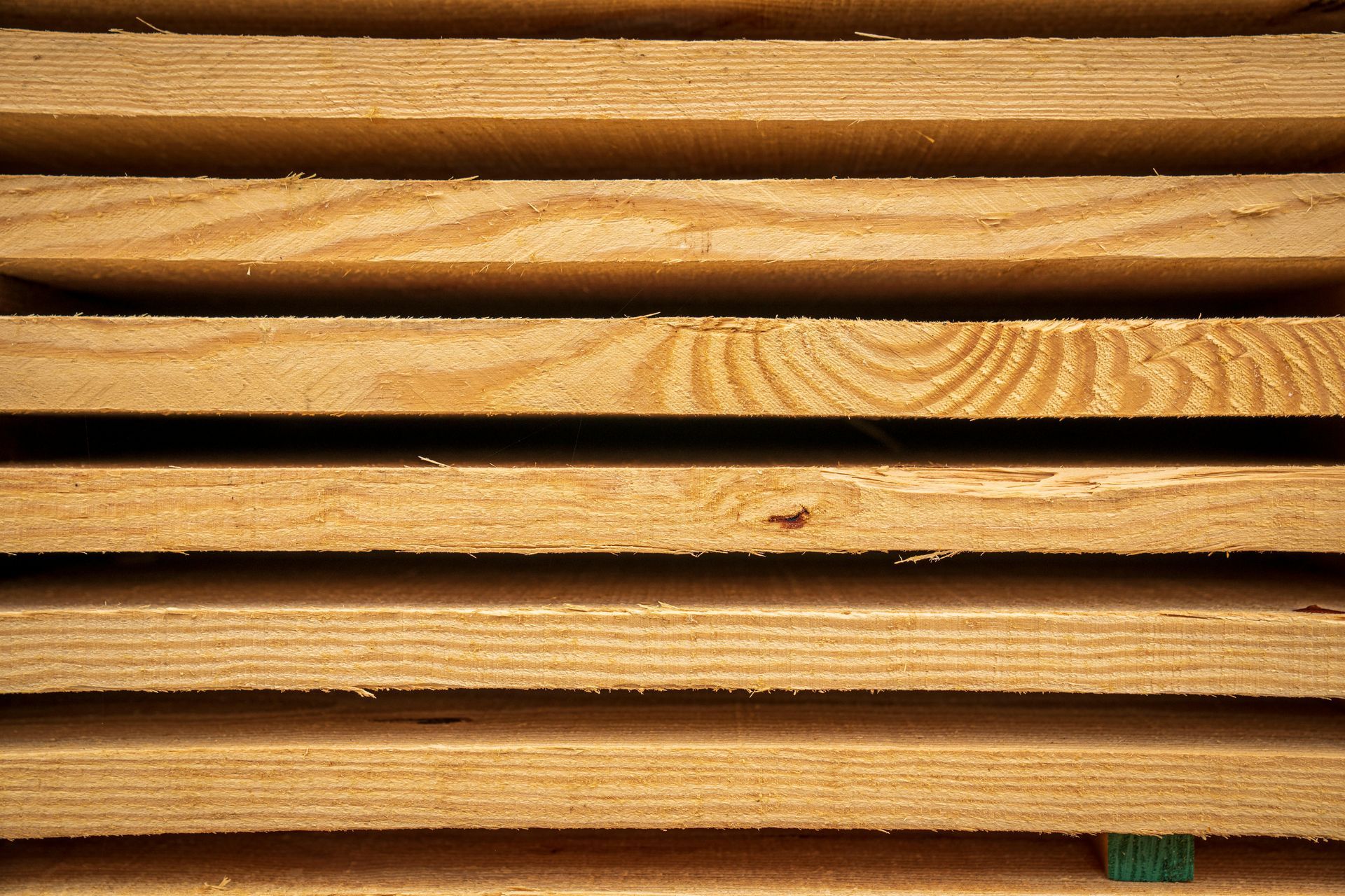 Stack of wooden boards, showing natural wood grain and texture.