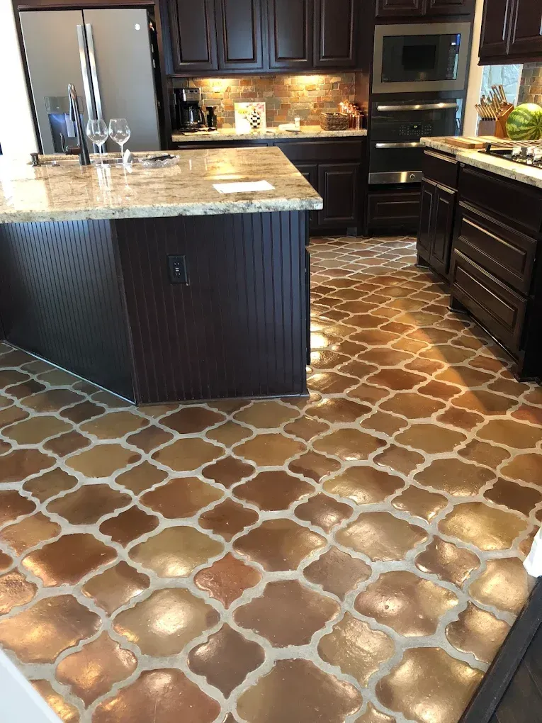 Kitchen with dark wood cabinets, a granite countertop island, and patterned brown tile flooring.