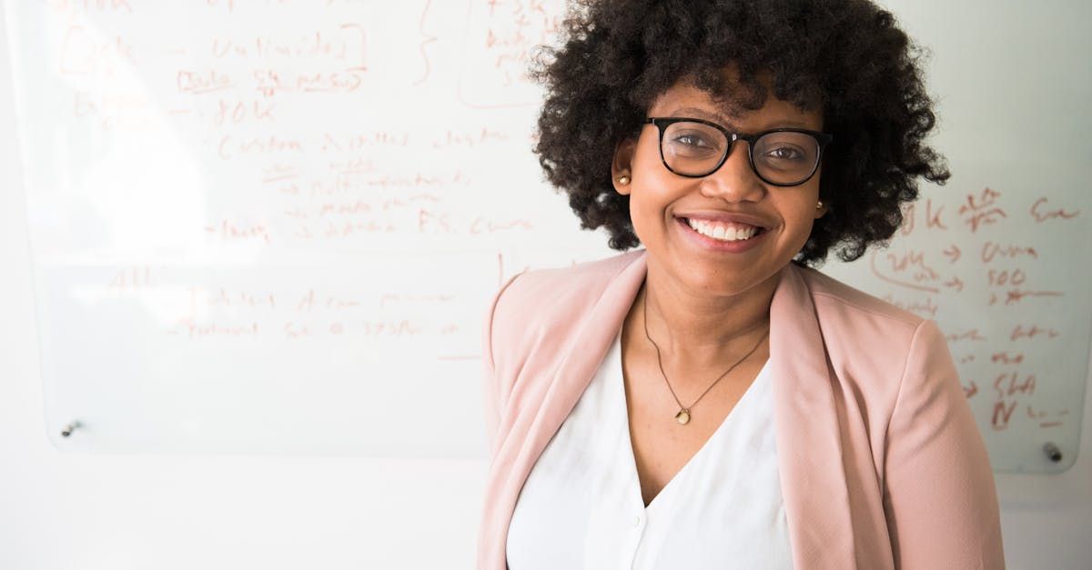 Twin Oaks image –woman in pink blazer smiling in front of a whiteboard, representing bookkeeping training and client support.