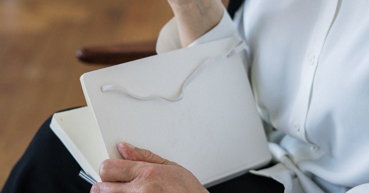 Person holding notebook and pen for bookkeeping indoors