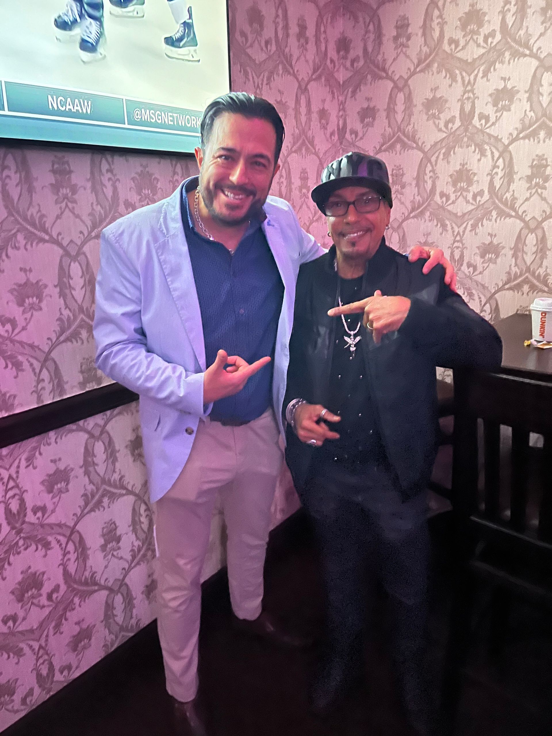 Two men are posing for a picture in a room