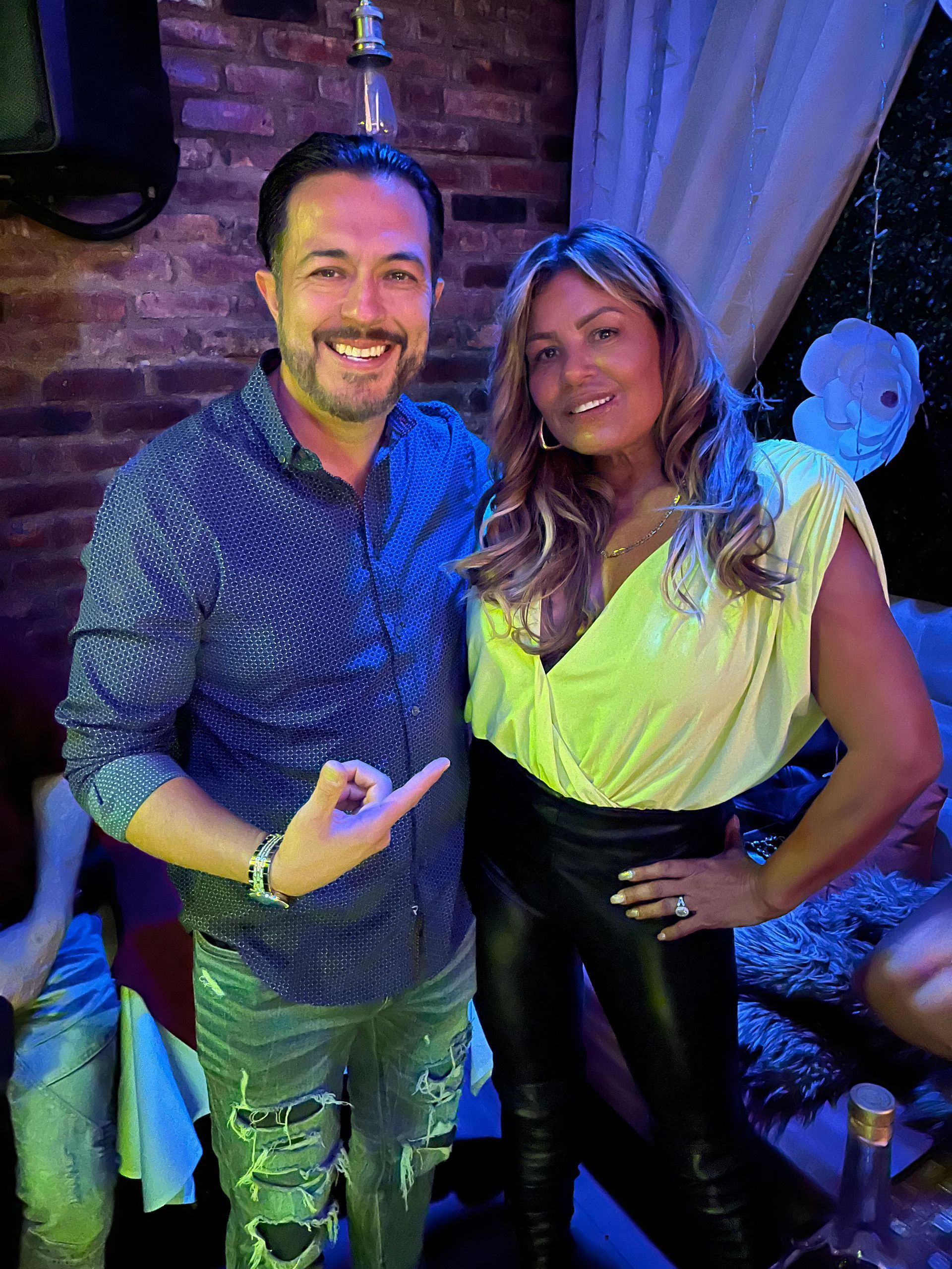 A man and a woman are posing for a picture in a dark room.