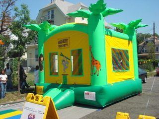 A green and yellow bouncy house with a giraffe on it