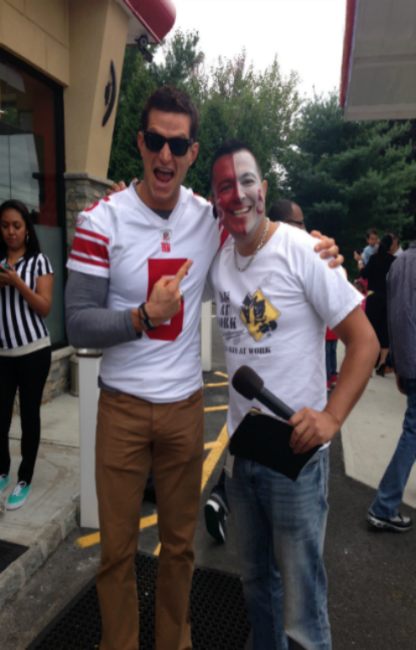 Two men are posing for a picture and one has a red cup in his hand