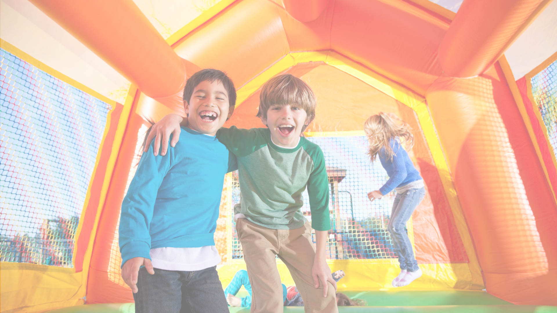 Two young boys are standing next to each other in a bouncy house.