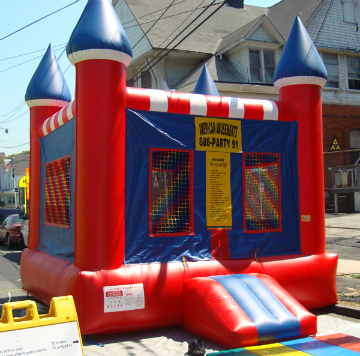 A red and blue bouncy castle with a sign that says we 're having a bouncy house party