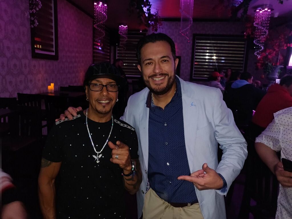 Two men posing for a picture in a dark room