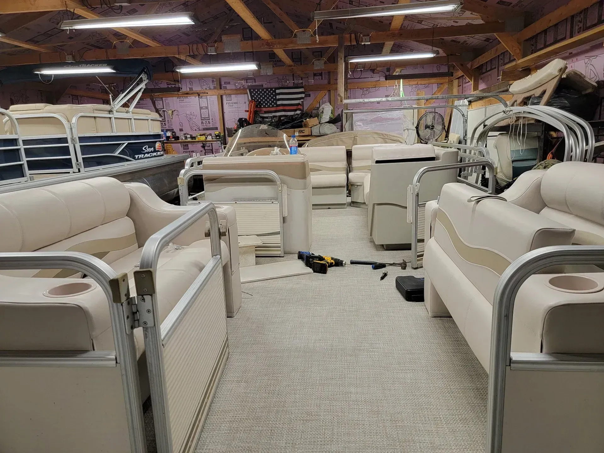 The inside of a boat is being built in a garage.