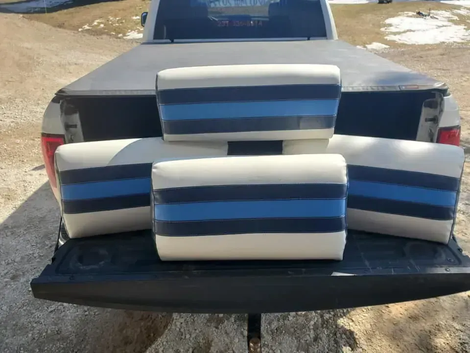 The back of a truck with blue and white striped seats.