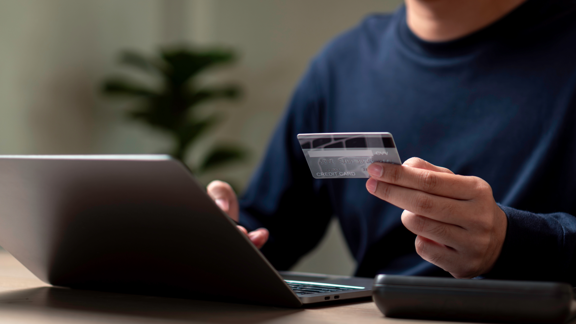 man paying with a credit card on his laptop