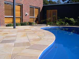 stone tiling by deep blue pool