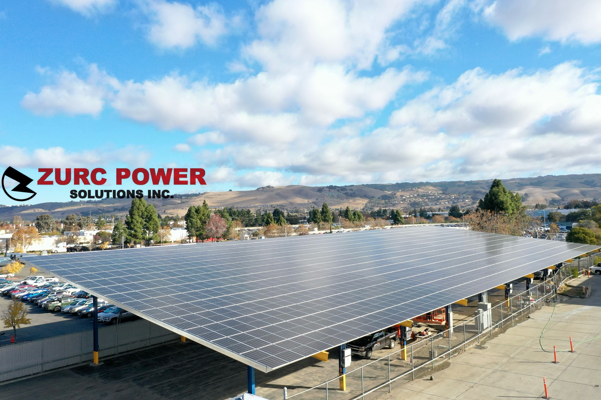 An aerial view of a parking lot covered in solar panels.