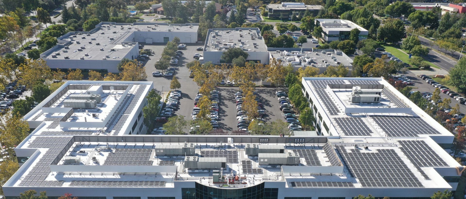 An aerial view of a large building with solar panels on the roof