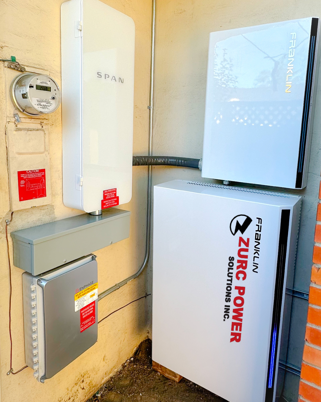 A white box with the word zurc power on it is sitting next to a brick wall.