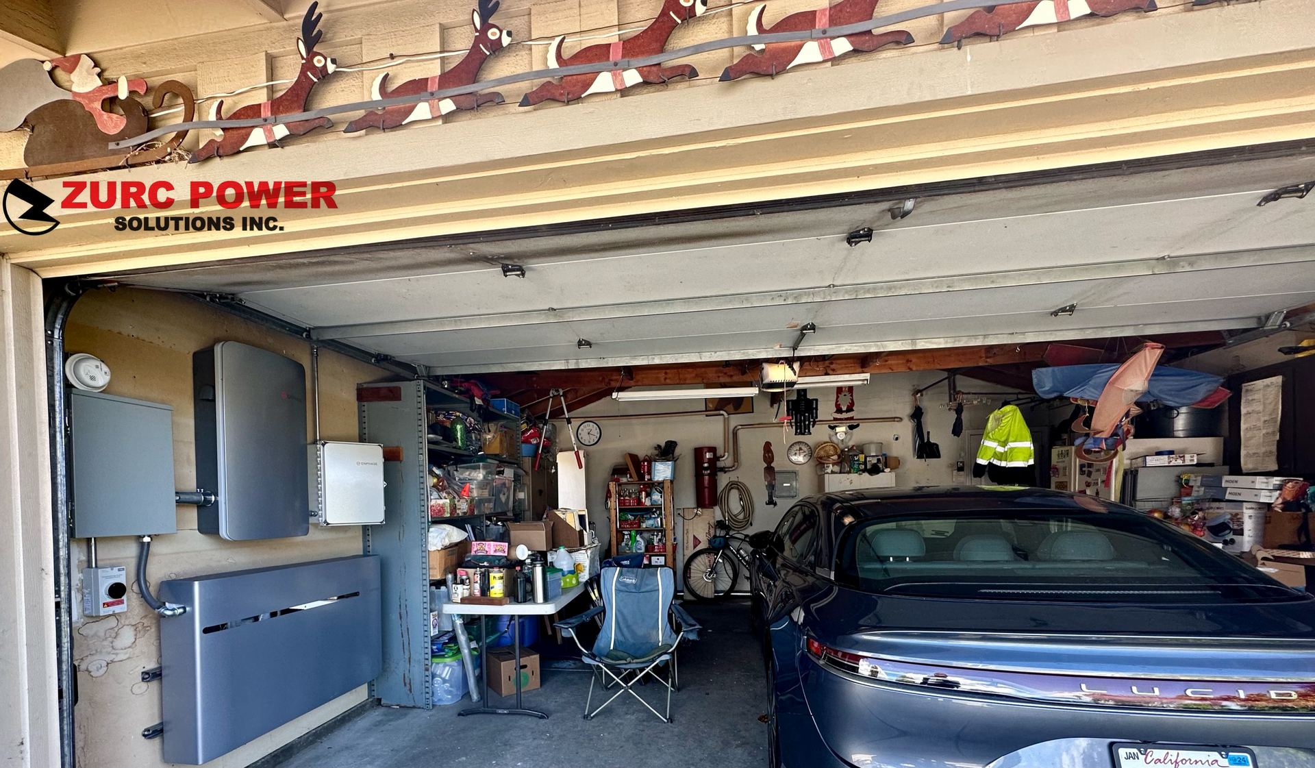 A car is parked in a garage with a table and chairs.