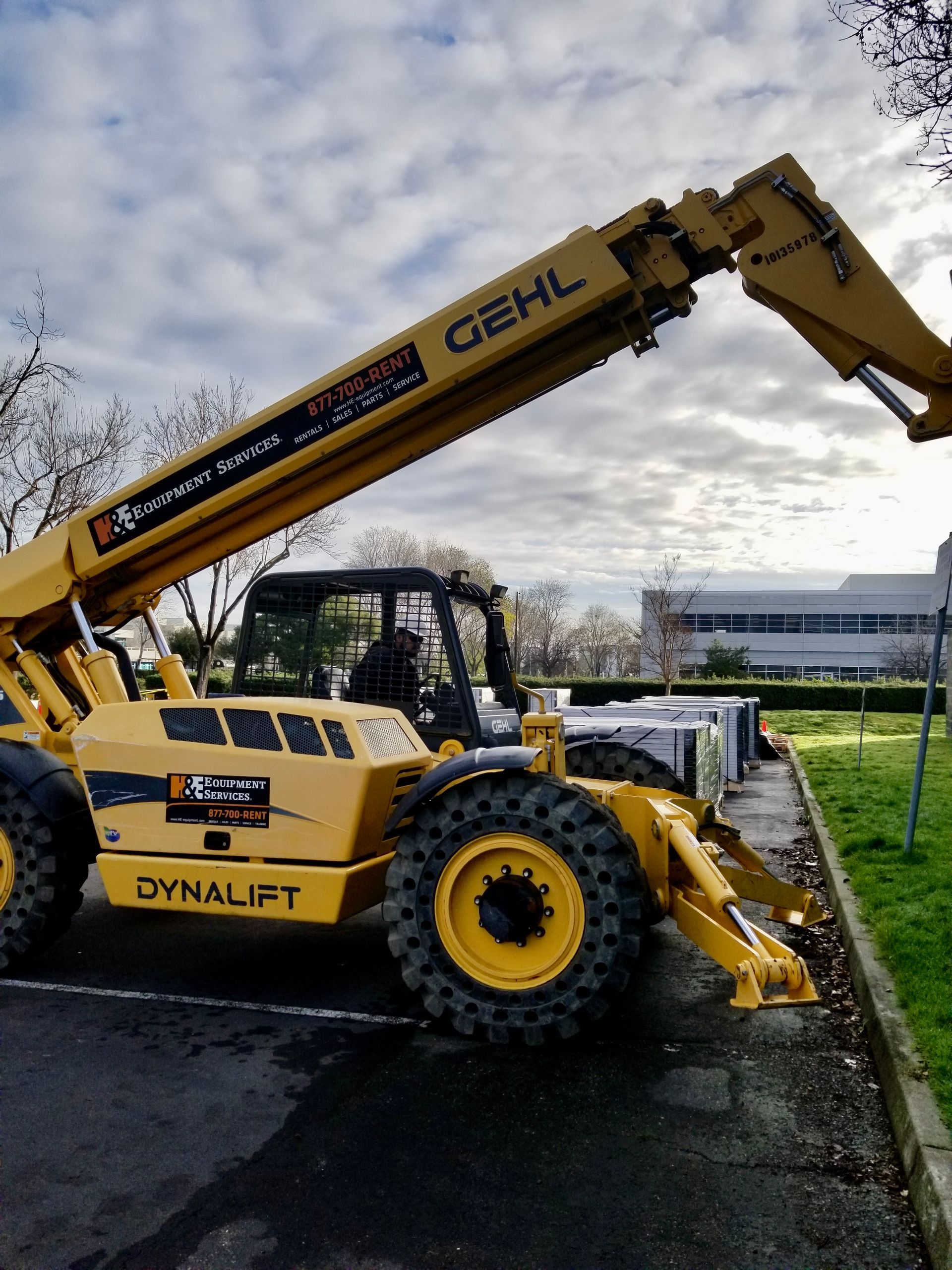 A yellow dynalift forklift is parked in a parking lot