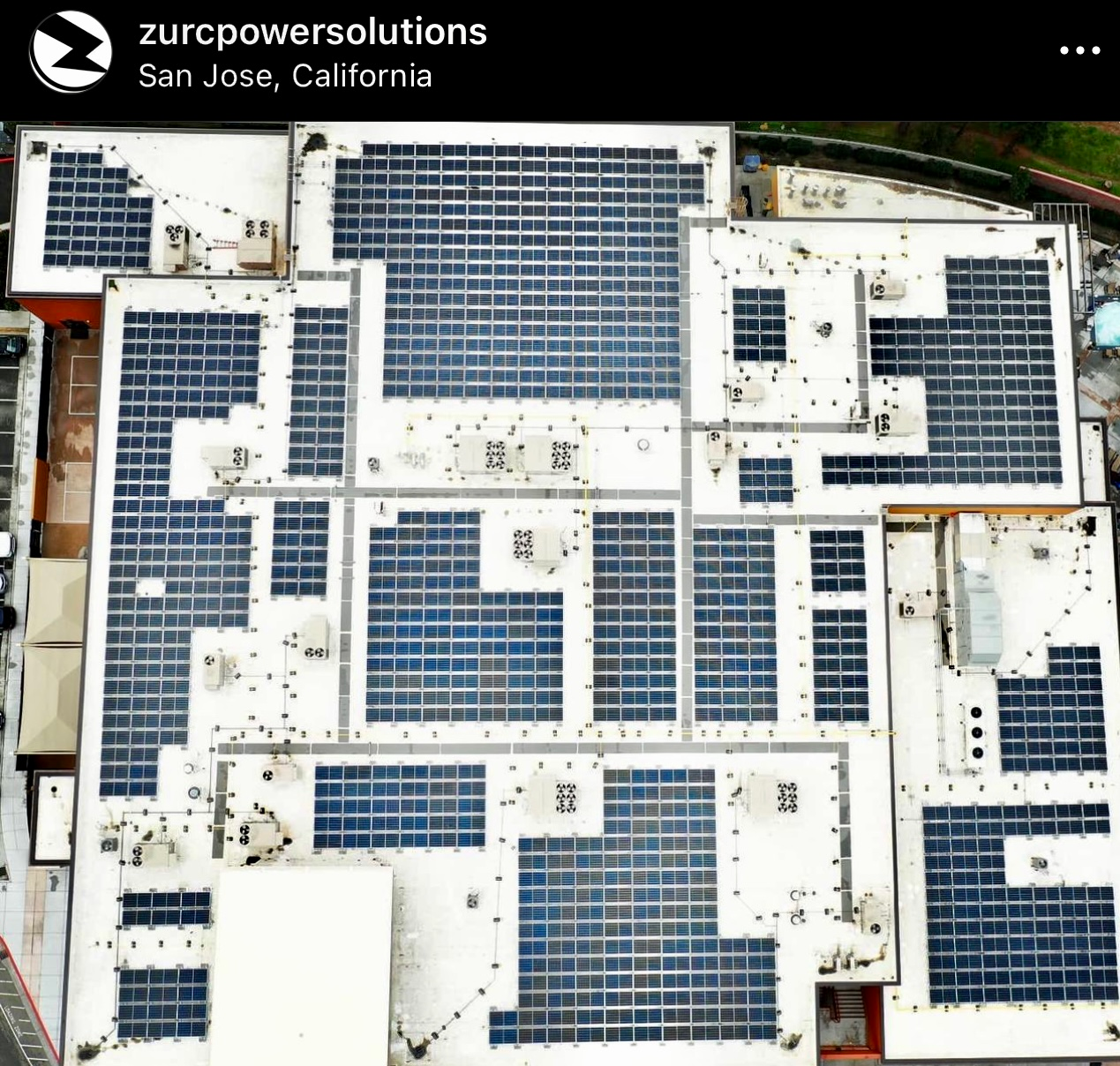 An aerial view of a building with solar panels on the roof