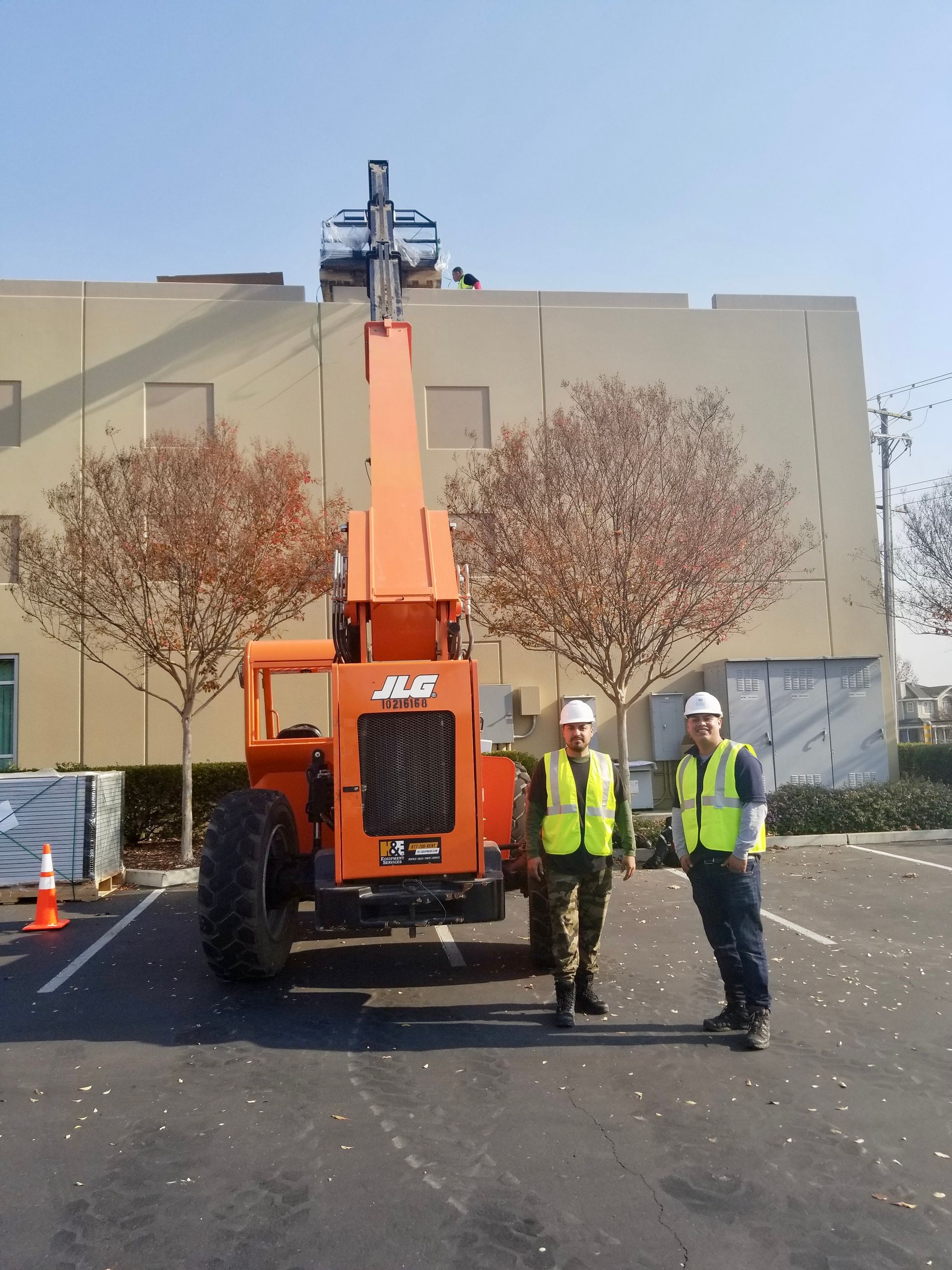 Two men standing in front of an orange jeep