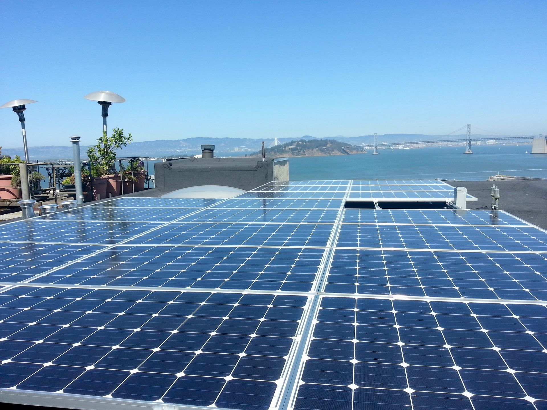 A row of solar panels on a roof overlooking the ocean