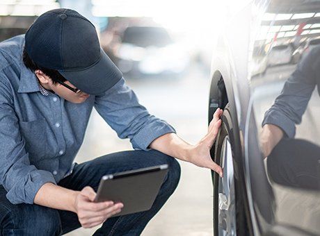 Auto Insurance Services — Man Checking Far Tire in Largo, FL