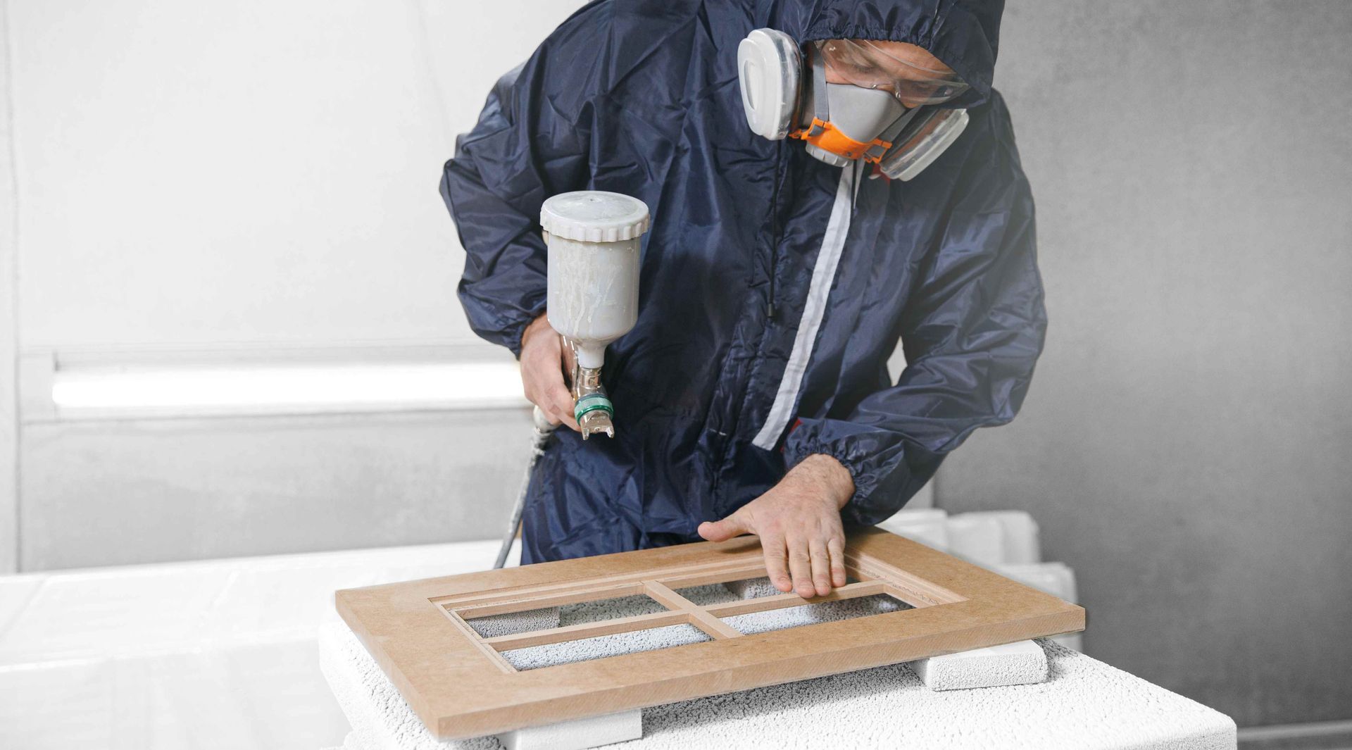 Man painting two doors over a white background