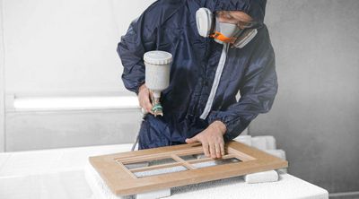 A man refinishing a cabinet door