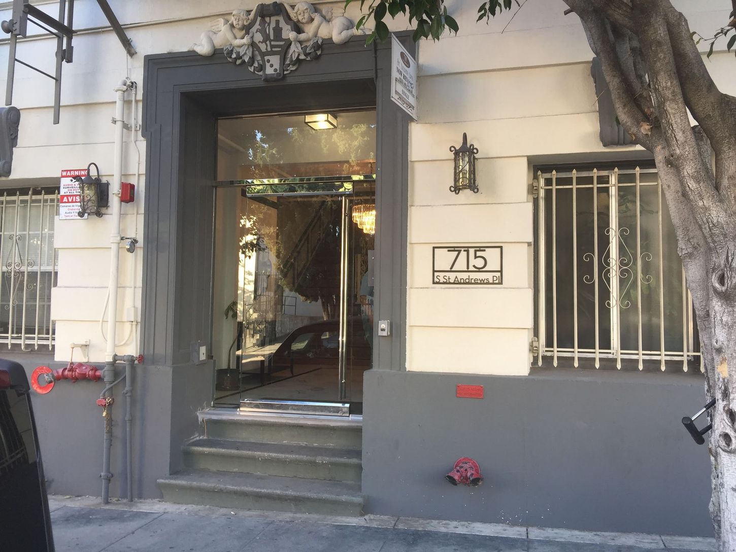 Gray building entrance with glass door and stairs; 