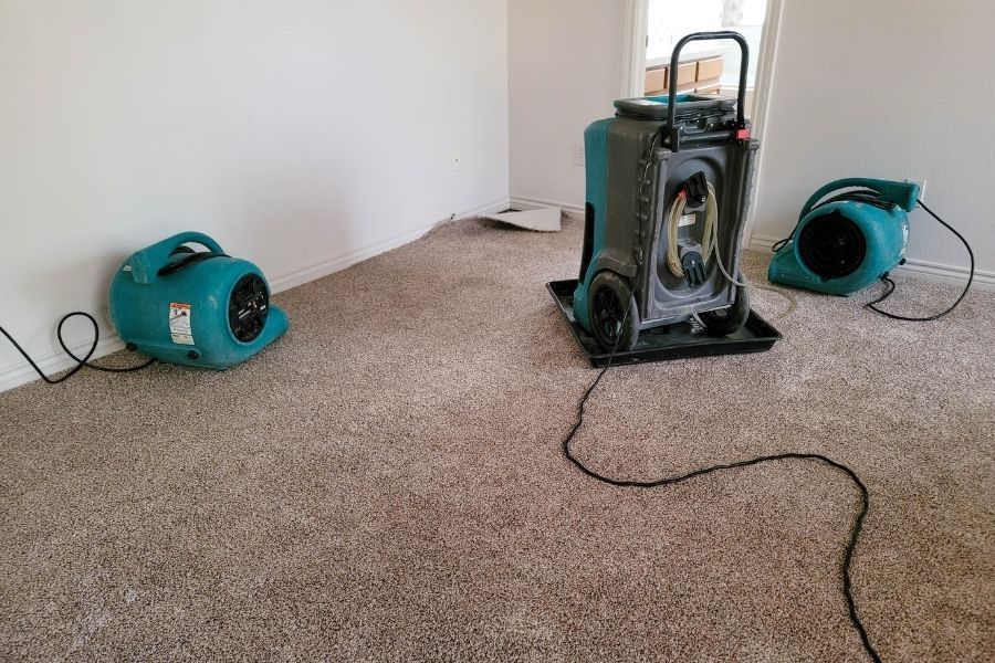 Professional drying equipment set up on carpet during water damage restoration