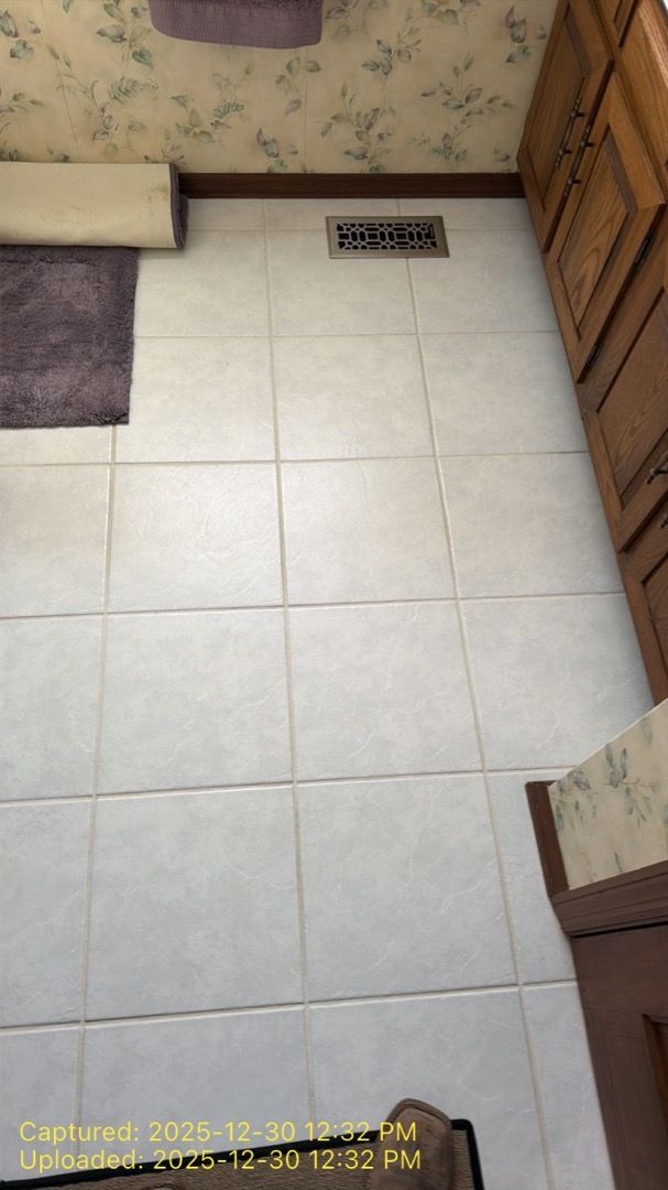 Technician checking moisture levels on bathroom tile floor after water damage