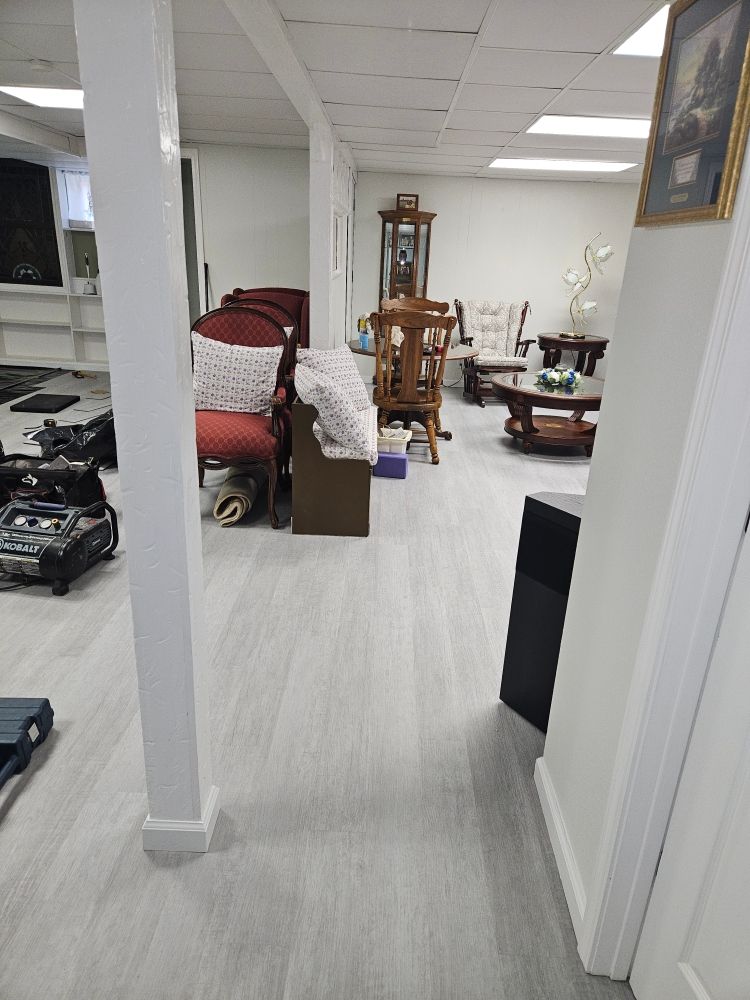 Finished basement after water damage restoration with new gray flooring