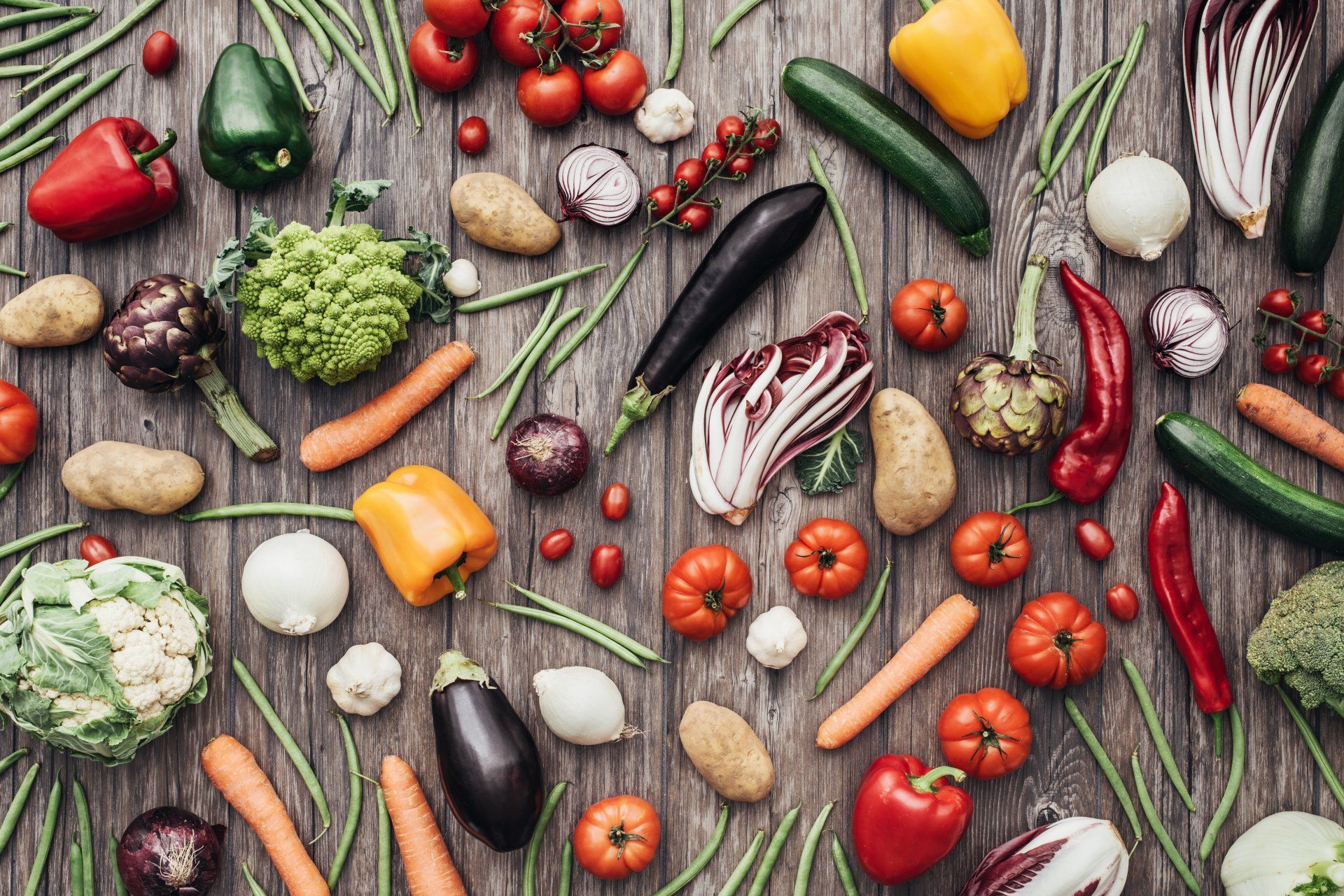 A wooden table topped with a variety of vegetables.