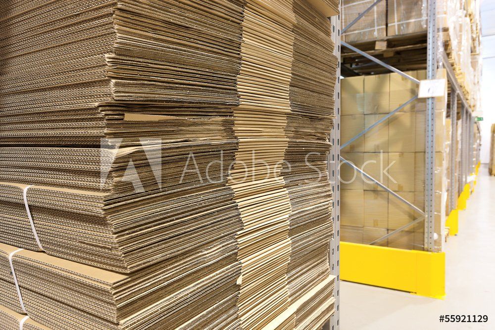 A warehouse filled with lots of cardboard boxes stacked on top of each other.