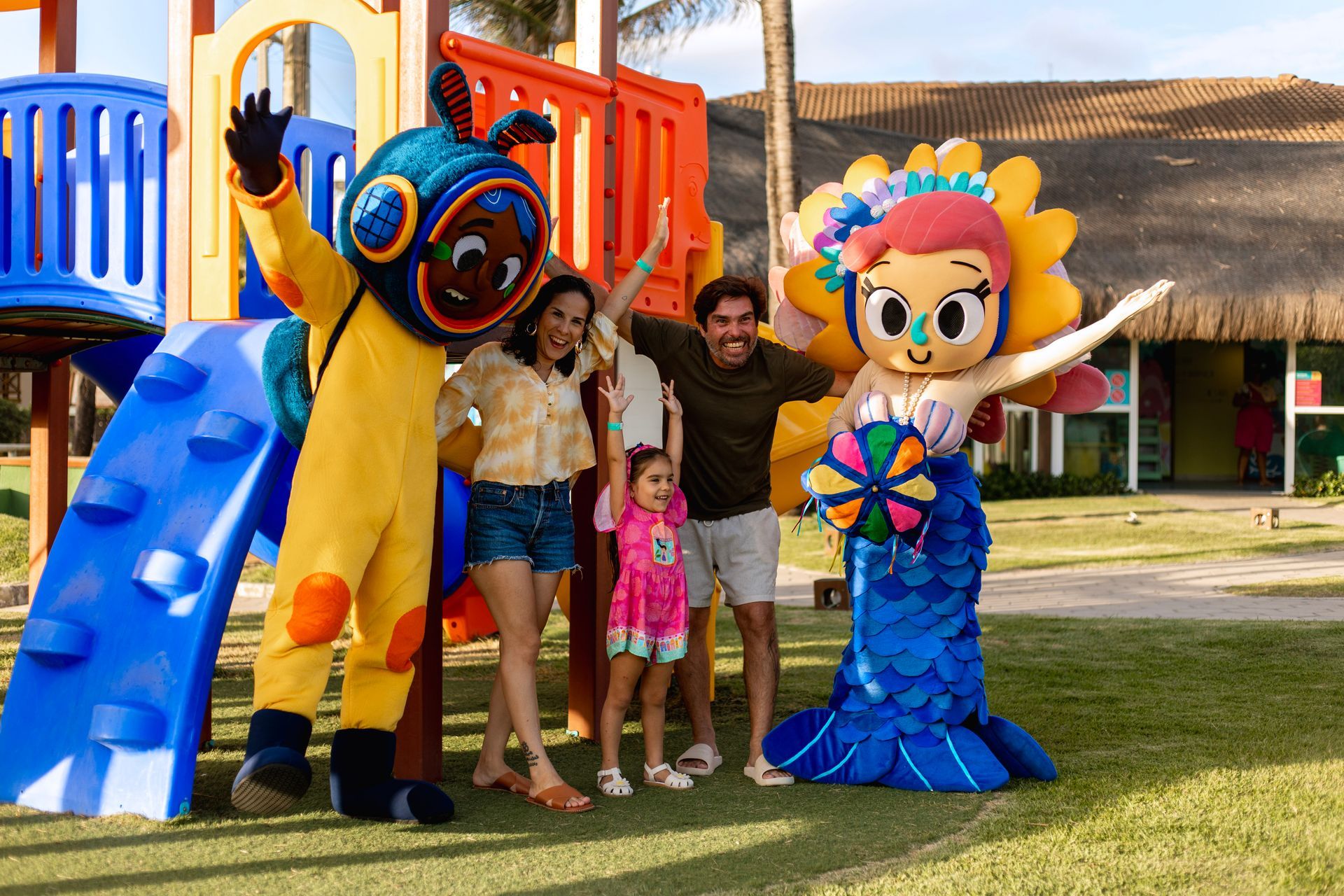 Família com criança em parquinho com personagens do Armação resort de praia em Porto de Galinhas