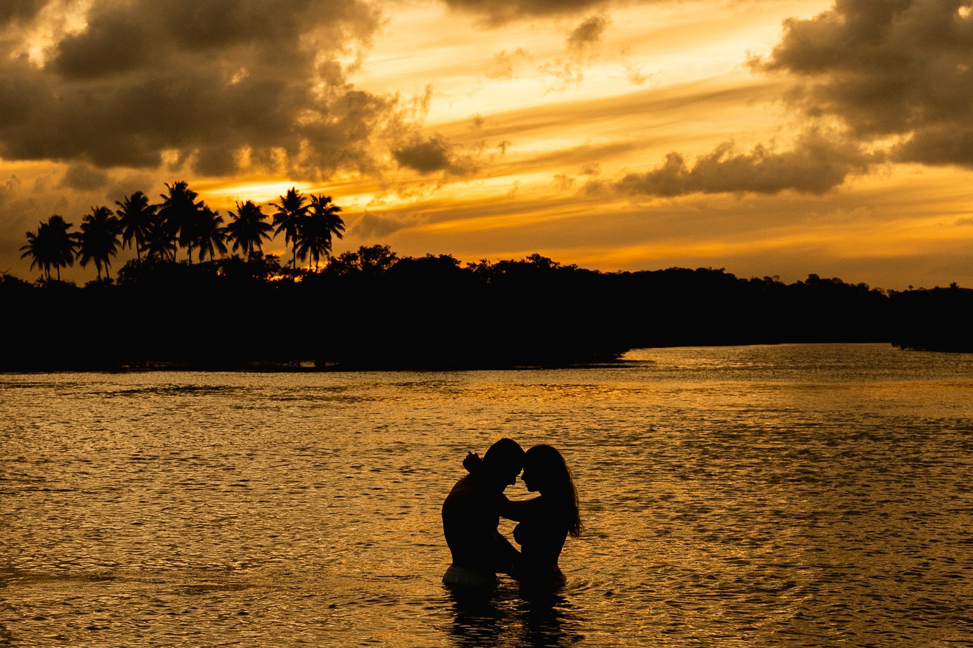 personagens fantasiados de coelho da Páscoa liderando grupo de crianças em atividade ao ar livre no resort, com área externa, coqueiros e hóspedes ao fundo.